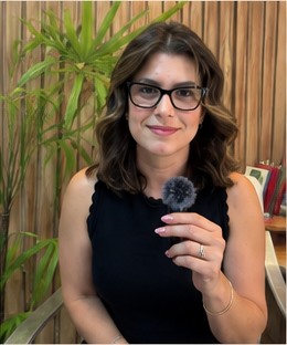 Lucele Viola segurando um microfone em atendimento